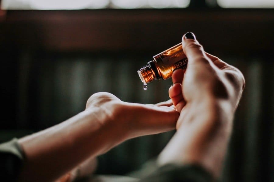 Embracing Lavender Oil is the Key to Sleep for Shift Workers - Dripping oil onto hands - The Other Shift