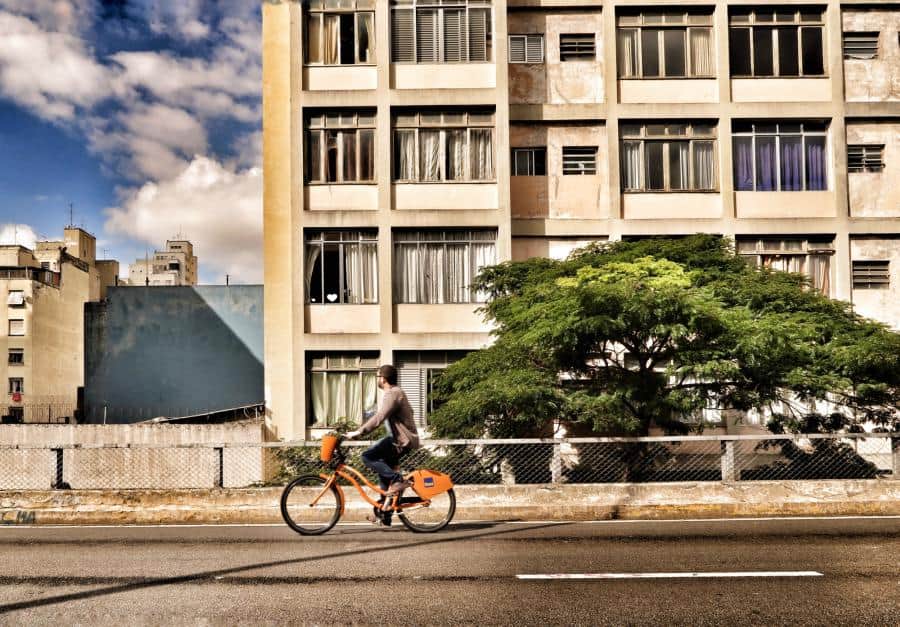 Women ridding orange bike next to building How Do You Adapt to Shift Work? | 7 Tips to Transition Quickly