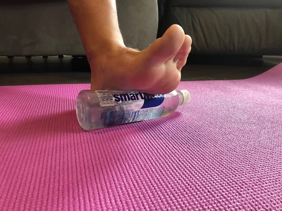 How to Relieve Foot and Leg Pain from Standing All Day in 6 Simple Steps - Dan rolling foot on iced bottle