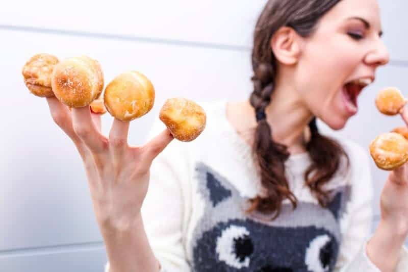 Vrouw met donuts op vingers