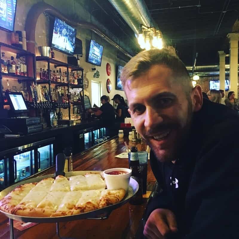 Dan with pizza in a bar