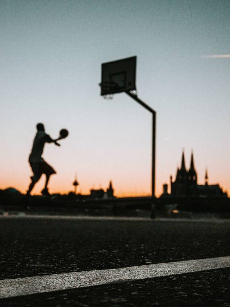 Person shooting basketball at dusk | What's the Best Exercise Workout Routine for Shift Workers?