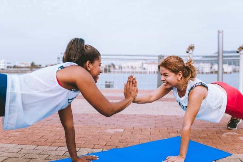 Two women working out together smiling | What's the Best Exercise Workout Routine for Shift Workers?